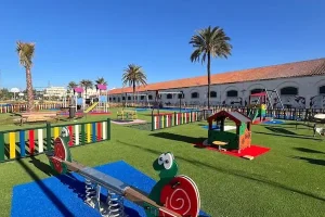 parque-infantil-balancin Balancín en parque infantil con césped artificial