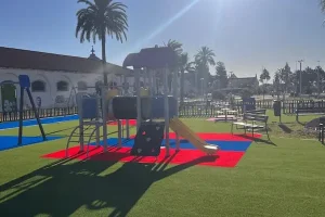 parque-infantil-tobogan Tobogán en parque infantil con césped artificial